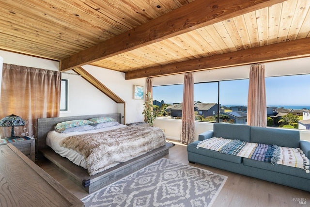 bedroom featuring beam ceiling, wood finished floors, and wooden ceiling