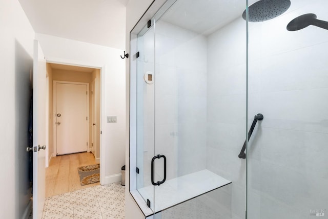 bathroom with a shower stall, toilet, baseboards, and tile patterned floors