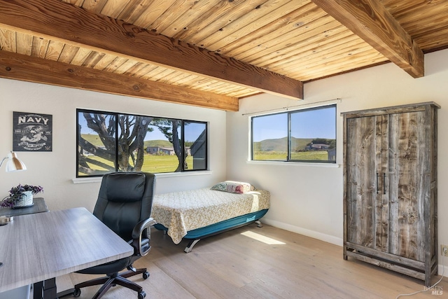 bedroom with baseboards, beam ceiling, wood ceiling, and wood finished floors