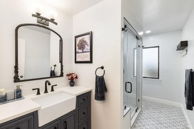 full bath featuring a stall shower, vanity, and baseboards