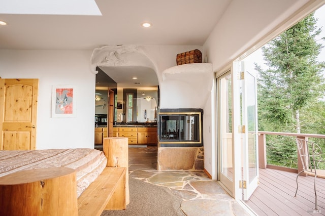 bedroom featuring recessed lighting, wood-type flooring, and a multi sided fireplace