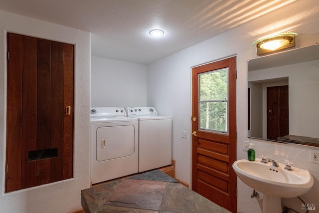 clothes washing area with laundry area, washing machine and dryer, and a sink