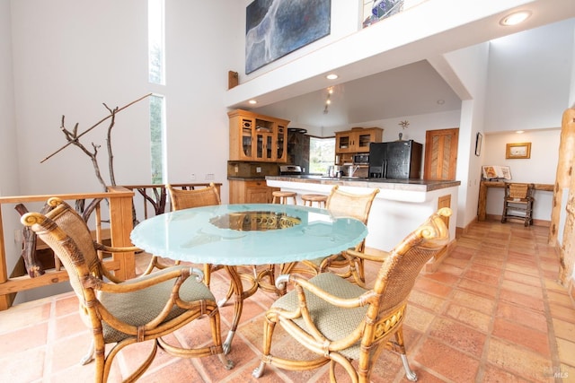 dining area with a towering ceiling and recessed lighting