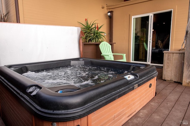 view of patio with a deck and a hot tub