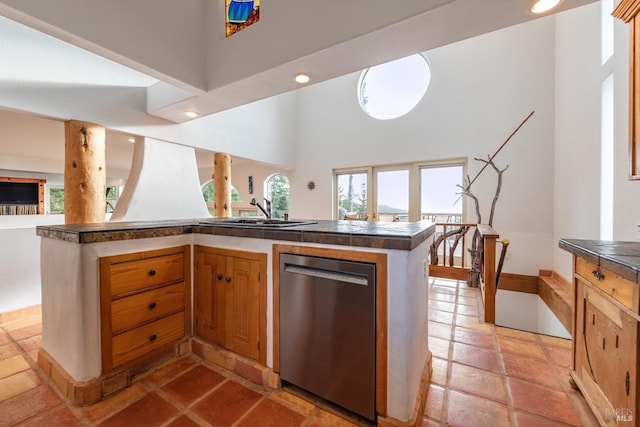 kitchen with recessed lighting, a high ceiling, a sink, stainless steel dishwasher, and dark countertops