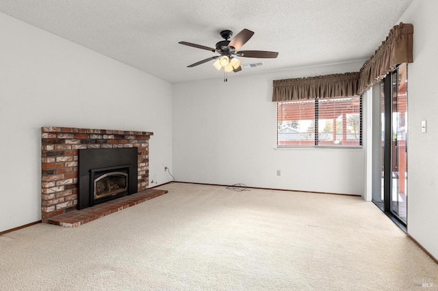 unfurnished living room with a textured ceiling, carpet floors, and a brick fireplace