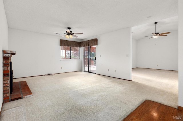 unfurnished living room featuring carpet floors, a brick fireplace, ceiling fan, and a textured ceiling