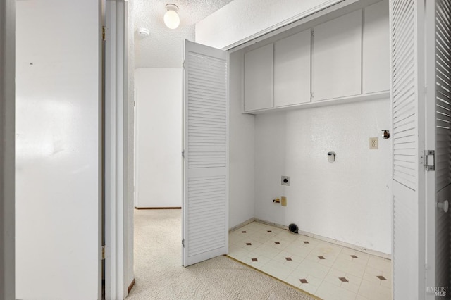 laundry room featuring light floors, light colored carpet, cabinet space, electric dryer hookup, and a textured ceiling