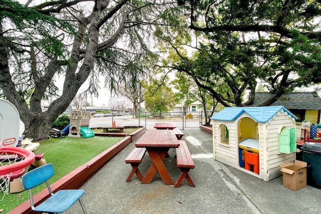 view of home's community featuring a yard, a gate, playground community, and fence