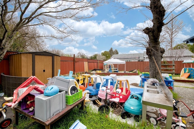 view of yard featuring a storage shed, a fenced backyard, an outbuilding, and a gazebo