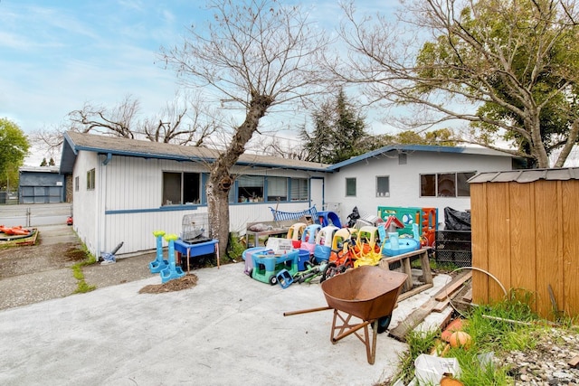 back of property featuring an outbuilding and a patio