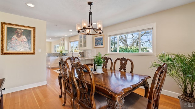 dining space featuring a chandelier, recessed lighting, baseboards, and light wood finished floors