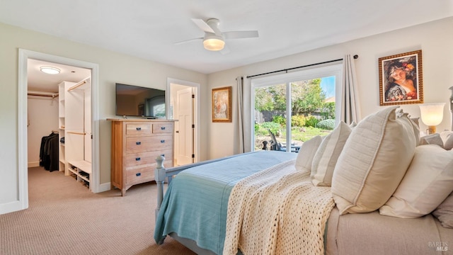 bedroom featuring ceiling fan, light colored carpet, baseboards, access to exterior, and a walk in closet