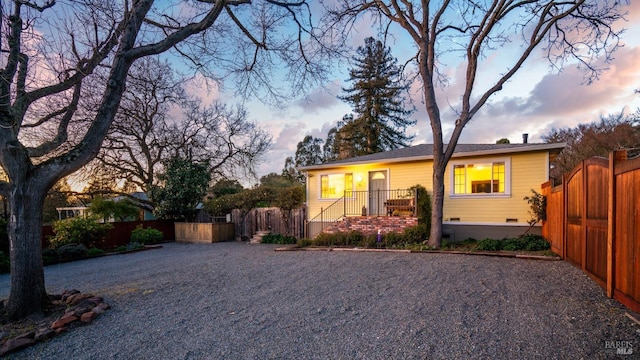 view of front of house featuring crawl space, fence, and gravel driveway