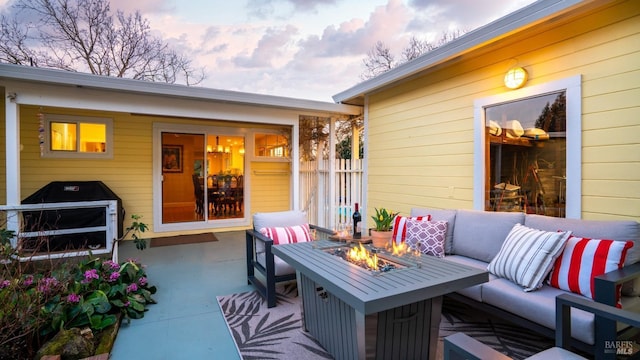 patio terrace at dusk with an outdoor living space with a fire pit