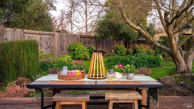 exterior space with a fenced backyard, a deck, and outdoor dining area