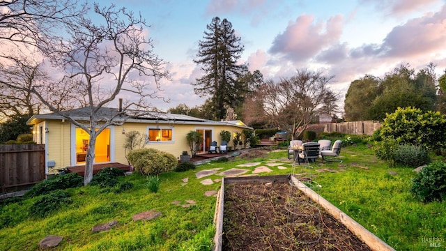 yard at dusk with fence and a garden