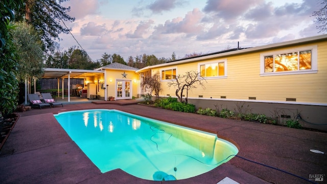 outdoor pool with a patio and french doors