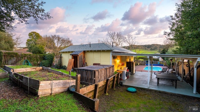 back of property with a fenced in pool, roof with shingles, a vegetable garden, a patio area, and a fenced backyard