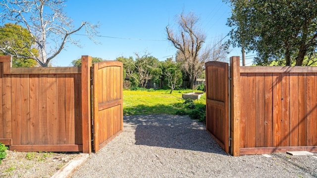 view of gate with a lawn and fence