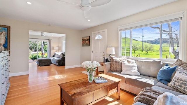 living room featuring light wood-style flooring, baseboards, a ceiling fan, and recessed lighting