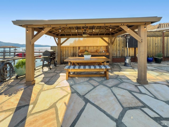 view of patio featuring a gazebo, area for grilling, fence, and a mountain view