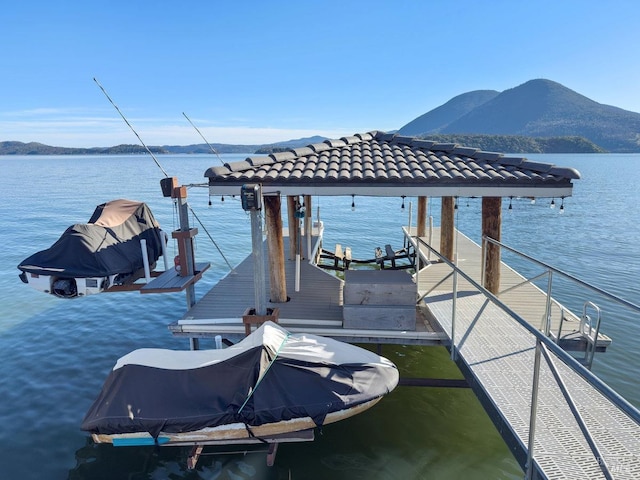 dock area with boat lift and a water and mountain view