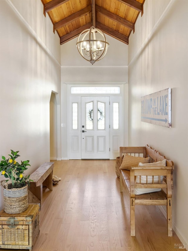 entrance foyer with high vaulted ceiling, light wood-style floors, wood ceiling, a chandelier, and beamed ceiling