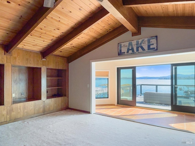 carpeted spare room with lofted ceiling with beams, built in shelves, wooden ceiling, and baseboards