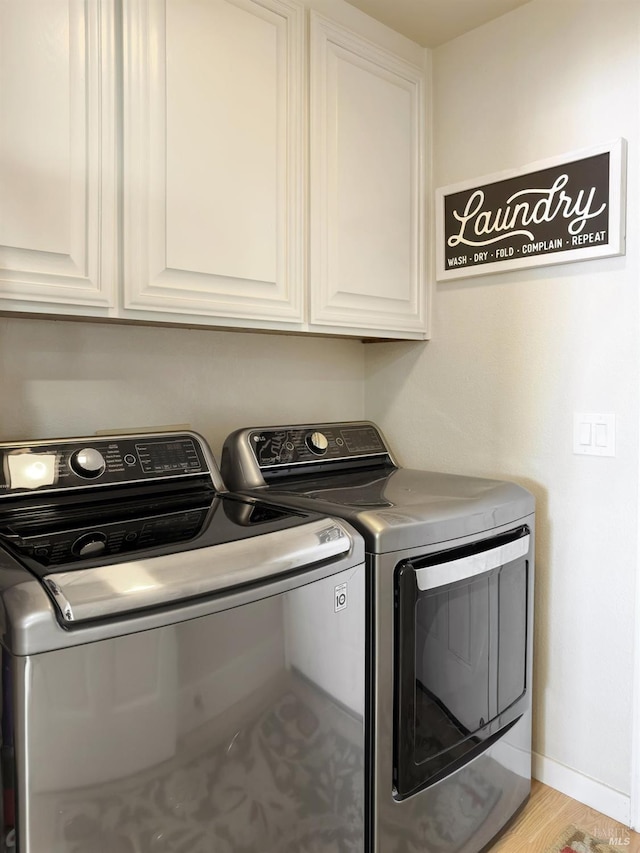 washroom featuring cabinet space, independent washer and dryer, and baseboards