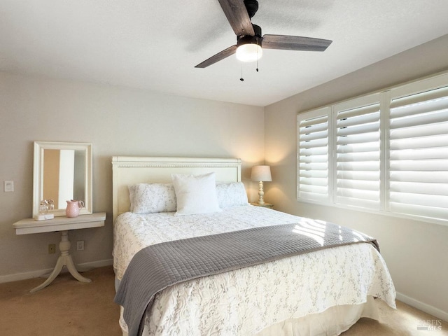 carpeted bedroom with ceiling fan and baseboards