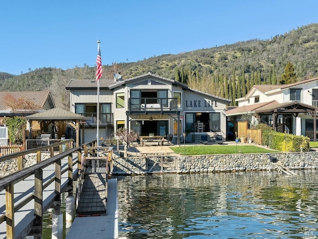 exterior space with a gazebo, a forest view, and a water view