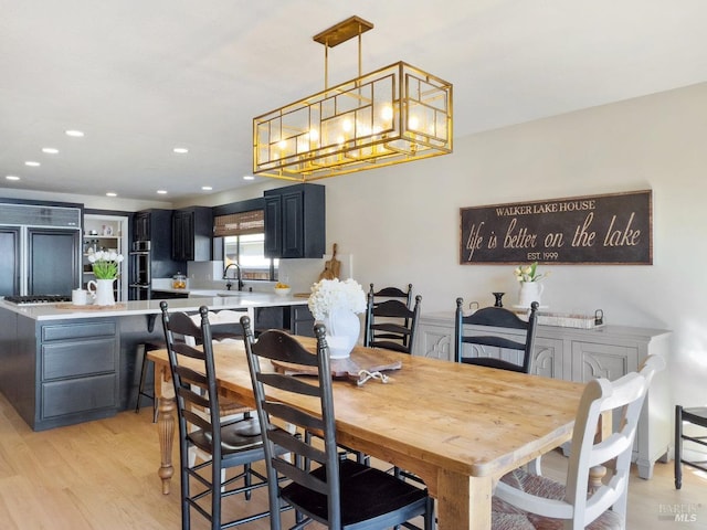 dining room featuring recessed lighting, a notable chandelier, and light wood-style flooring