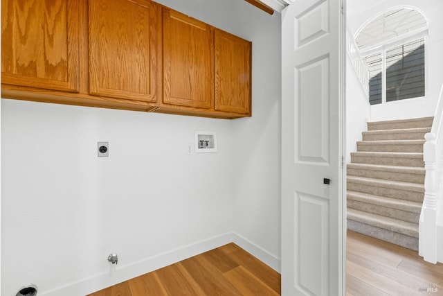 laundry area with cabinet space, baseboards, gas dryer hookup, hookup for a washing machine, and light wood-style floors