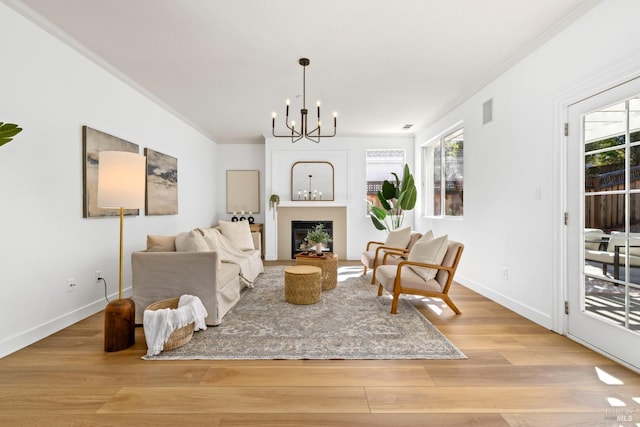 living area featuring crown molding, plenty of natural light, a fireplace, and wood finished floors