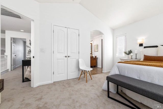 bedroom with arched walkways, lofted ceiling, visible vents, light carpet, and baseboards