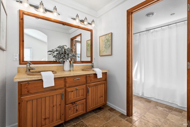 bathroom featuring stone tile floors, a shower with shower curtain, a sink, ornamental molding, and double vanity