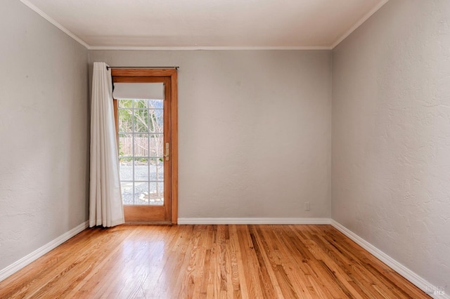 empty room with light wood finished floors, baseboards, crown molding, and a textured wall