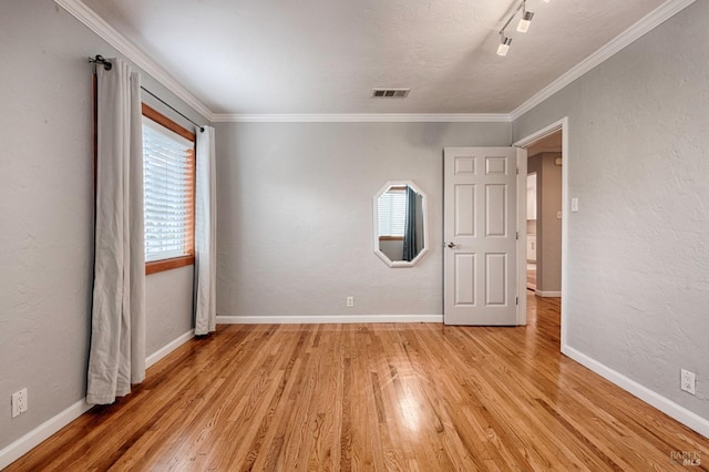 unfurnished room with light wood finished floors, visible vents, and baseboards