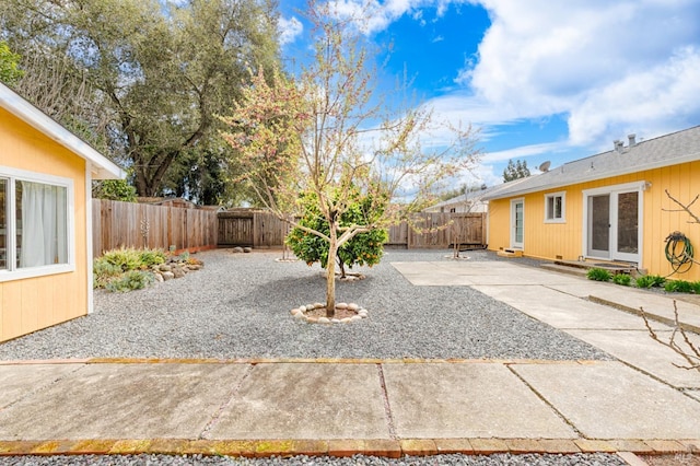 exterior space with a patio area, a fenced backyard, and french doors