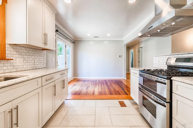 kitchen with crown molding, wall chimney range hood, recessed lighting, and double oven range