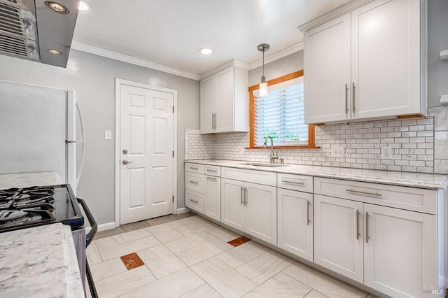 kitchen featuring a sink, ornamental molding, backsplash, freestanding refrigerator, and decorative light fixtures