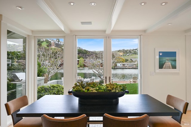 dining space with beamed ceiling, a water view, visible vents, and recessed lighting