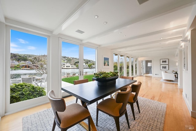 sunroom with a water view, visible vents, beam ceiling, and french doors