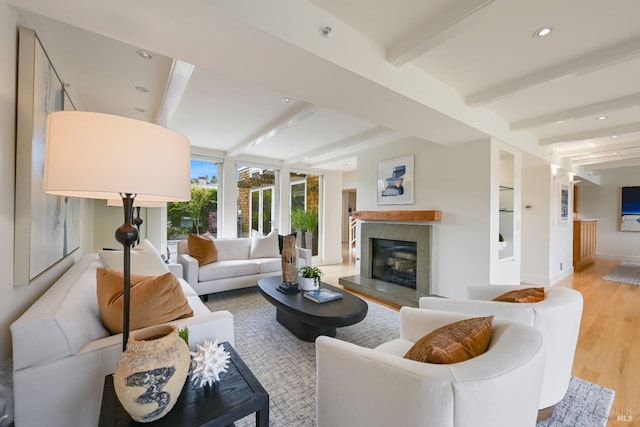 living area with baseboards, a high end fireplace, wood finished floors, beam ceiling, and recessed lighting