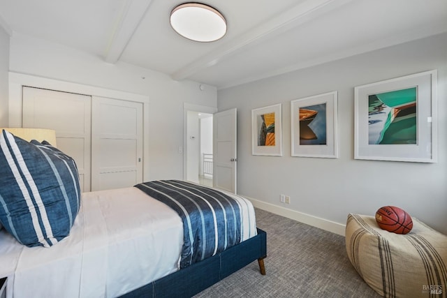 carpeted bedroom featuring a closet, beam ceiling, and baseboards