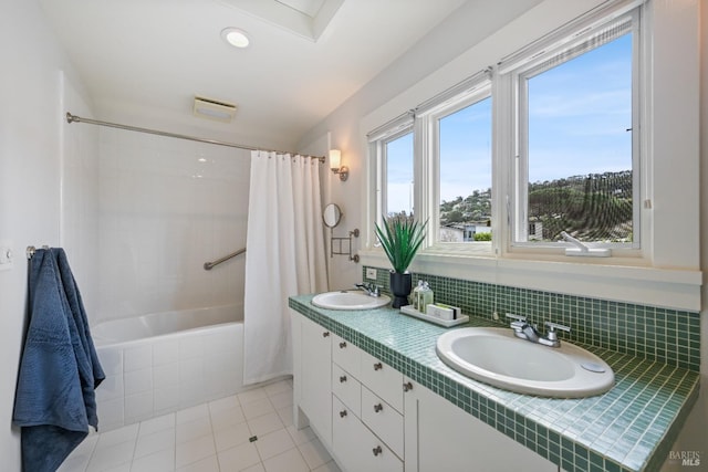 bathroom featuring shower / bath combo, tile patterned flooring, a sink, and double vanity