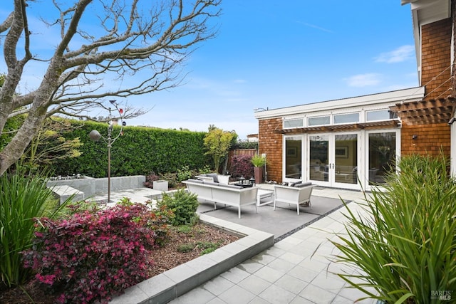 view of patio / terrace featuring french doors, outdoor lounge area, and fence