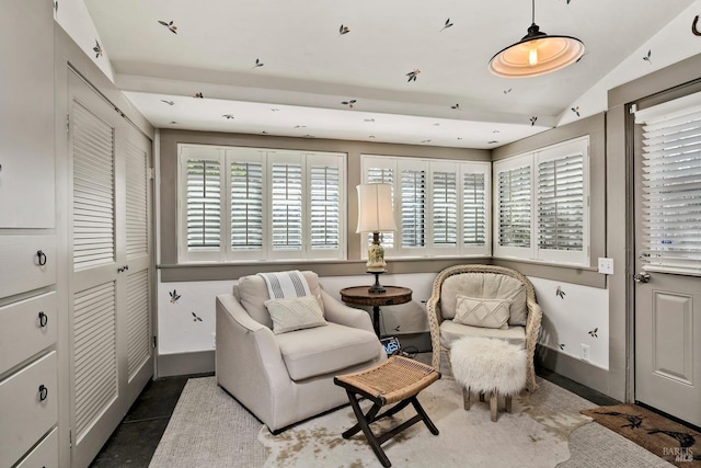 sitting room with lofted ceiling and baseboards