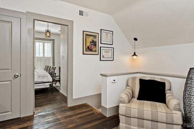 living area featuring lofted ceiling, dark wood finished floors, visible vents, and baseboards